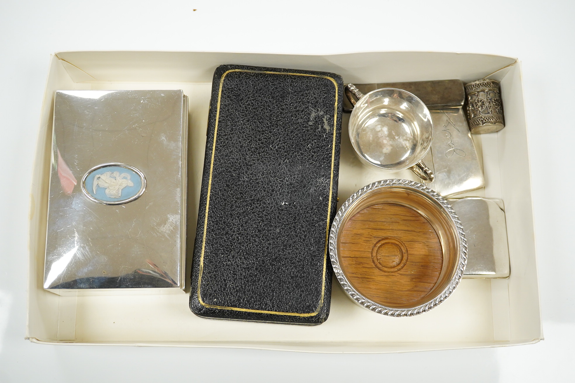 Sundry silver including a cigarette box (marks rubbed), 13.2cm, cased tea strainer, mounted wine coaster, small cup, match sleeve, card case, small case and 925 cylindrical box and cover. Condition - poor to fair to good